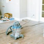 Vacuum and tools in a room undergoing renovation, showcasing home improvement.